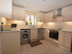 a kitchen with white cabinets and a dishwasher at 2 Bed in Fairbourne 43105 in Arthog