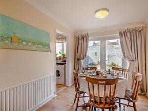a dining room with a table and chairs and a window at 3 Bed in Sheringham 43467 in Sheringham