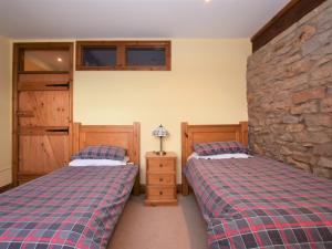 2 Betten in einem Zimmer mit einer Steinmauer in der Unterkunft 4 Bed in Whaley Bridge PK535 in Whaley Bridge