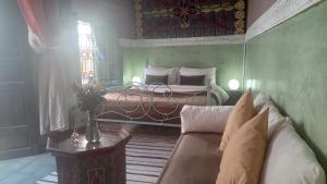 1 dormitorio con 1 cama y 1 sofá en una habitación en Riad Maizie, en Marrakech