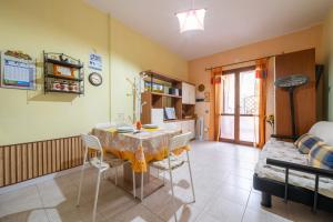 维拉西米乌斯Pentagramma Apartment Villasimius的配有桌椅的厨房和客厅