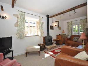 a living room with a couch and a fireplace at 1 Bed in Bourton-on-the-Water 44961 in Withington