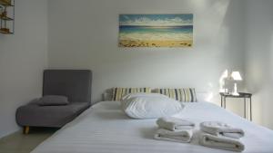 een slaapkamer met een bed met handdoeken erop bij Nest Port View Apartment in Volos
