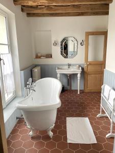 a bathroom with a white tub and a sink at Entre les branches in Saint-Règle