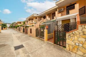 维拉西米乌斯Pentagramma Apartment Villasimius的排有门和人行道的房屋