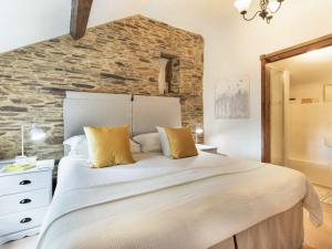 a bedroom with a large bed and a stone wall at 1 Bed in Yelverton 53533 in Yelverton