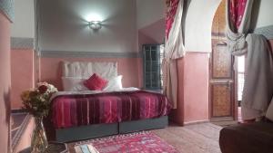 a bedroom with a bed with pink walls at Riad Maizie in Marrakesh