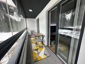 a room with a table and some glass windows at Staza Ski Apartment in Jahorina