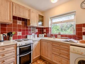 a kitchen with wooden cabinets and a window at 2 Bed in Coleford 60103 in Coleford +6 photos