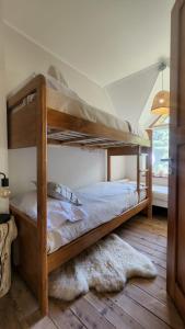 drewnianym łóżkiem piętrowym w pokoju z dywanem w obiekcie Luna Roja Llao Llao w mieście Bariloche
