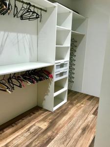 einen begehbaren Kleiderschrank mit weißen Schränken und Holzböden in der Unterkunft Appartement au calme in Propriano