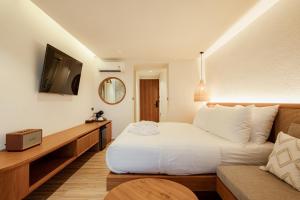 een hotelkamer met een bed en een bank bij Tasana bar and luxury resort in Ko Larn