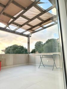 einen Balkon mit einem Tisch und einem Fenster in der Unterkunft Appartement au calme in Propriano