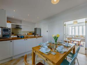een keuken met een houten tafel met stoelen en een eetkamer bij 3 Bed in Bexhill on Sea BT037 in Bexhill