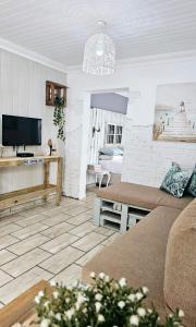 een woonkamer met een bank en een tv bij le'Cottage on Raymond in Scottburgh