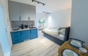 een kleine slaapkamer met een bed en een keuken bij Maxim Apartments in Mostar