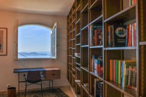 Zimmer mit Fenster und Bücherregalen in der Unterkunft Villa avec vue mer panoramique in Carqueiranne