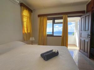 Un dormitorio con una cama con una toalla. en Ocean View Villa - Beauvallon villas en Beau Vallon