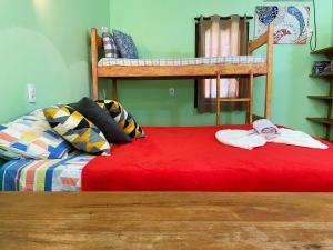a bedroom with two bunk beds and a red bed at Barra Quintal - Studio 1 in Barra Grande