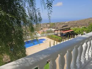 balcón con vistas a la piscina en Cool 4-bedroom Villa with sea views, en Tijoco de Abajo