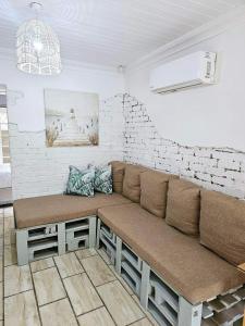 kanapa w pokoju z ceglaną ścianą w obiekcie le'Cottage on Raymond w mieście Scottburgh