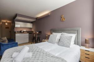 1 dormitorio con 1 cama blanca grande y cocina en Beautiful mountain view studio by the lake en Chamonix-Mont-Blanc