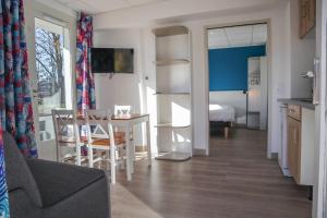 sala de estar con mesa y habitación con cama en Le Pavillon des Fleurs en Menthon-Saint-Bernard