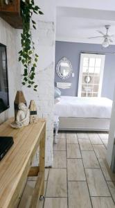 een kamer met een bed, een tafel en een spiegel bij le'Cottage on Raymond in Scottburgh