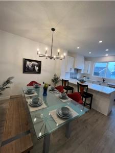 a dining room and kitchen with a glass table with red chairs at Entire4BedroomHomeKingParkingKitchenWasherDryerFastWiFi in Calgary