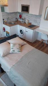 Zimmer mit einem Bett und einer Küche mit einem Waschbecken in der Unterkunft Studio escale élégante - proche gare Saint-Brieuc in Saint-Brieuc