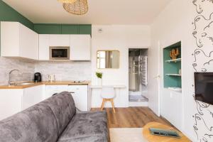 ein Wohnzimmer mit einem Sofa und einer Küche in der Unterkunft Studio escale élégante - proche gare Saint-Brieuc in Saint-Brieuc