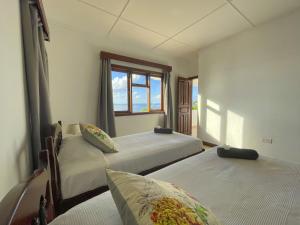 two beds in a room with a window at Beach View Villa - Beauvallon villas in Beau Vallon