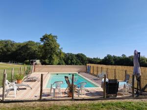 a swimming pool with chairs and a fence around it at Mobil home Vergnelibert in Chalais