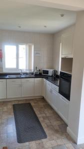 a kitchen with white cabinets and a black appliances at Spacious Victorian Double Room 3 in Balby