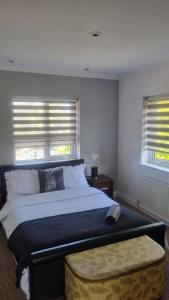 a bedroom with a large bed and two windows at Spacious Victorian Double Room 3 in Balby