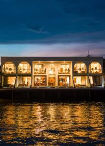 een gebouw naast het water 's nachts bij Tasana bar and luxury resort in Ko Larn
