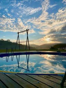 a reflection of a swing set in a pool of water at Casa vista da serra in São João del Rei