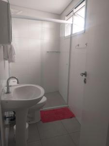 y baño blanco con lavabo y ducha. en Flat Centro de São Paulo, en São Paulo