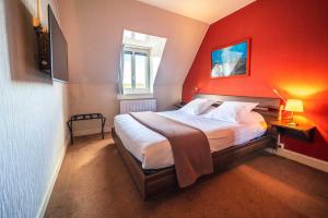 1 dormitorio con 1 cama grande y pared roja en Hôtel Le Goëlo - Port de Paimpol en Paimpol