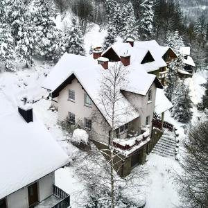シュチルクにあるPensjonat Malinówkaの雪に覆われた家屋の空見
