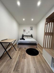 - une chambre avec un lit, un bureau et une table dans l'établissement Appartement chaleureux en hyper centre de Gap, à Gap