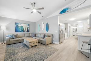 ein Wohnzimmer mit einem Sofa und einem Tisch in der Unterkunft Blue Neptune at 5313 Sunset Avenue by Nautical Properties Vacation Rentals in Panama City Beach