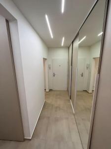 un corridoio vuoto di un edificio per uffici con specchi di New spacious one-room apartment a Prievoz