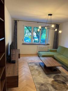 un soggiorno con divano verde e tavolo di New spacious one-room apartment a Prievoz