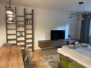 a living room with a dining table and a television at New spacious one-room apartment in Prievoz