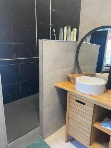 a bathroom with a shower and a sink and a mirror at Maison 2 chambres tout équipée in Vitry-en-Artois