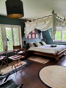 1 dormitorio con 1 cama grande y 1 silla en Chambres d'Hôtes Le Grismoustier, en Veulettes-sur-Mer