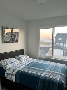 - une chambre avec un lit et une fenêtre dans l'établissement Entire4BedroomHomeKingParkingKitchenWasherDryerFastWiFi, à Calgary
