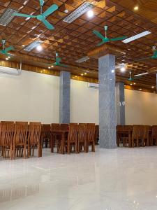 um quarto amplo com cadeiras de madeira e um tecto em Khách sạn Trường Giang em Thanh Hóa