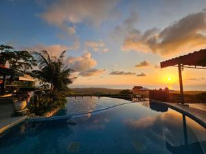 Una puesta de sol sobre una piscina en un resort en Vista Ballena, en Uvita
